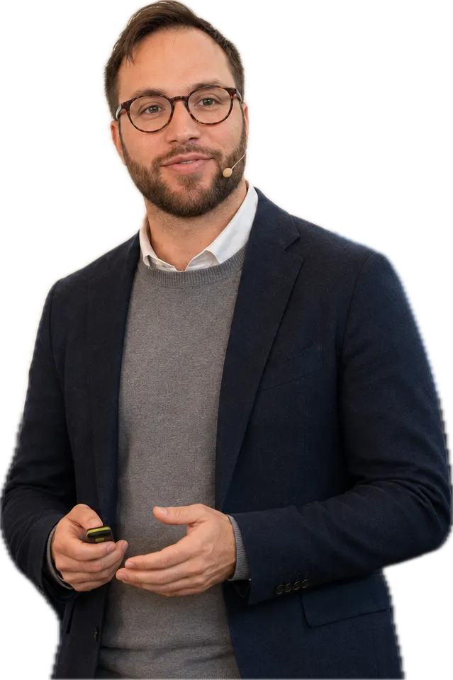 Tal Aloni, in a navy blazer and headset microphone, presenting.